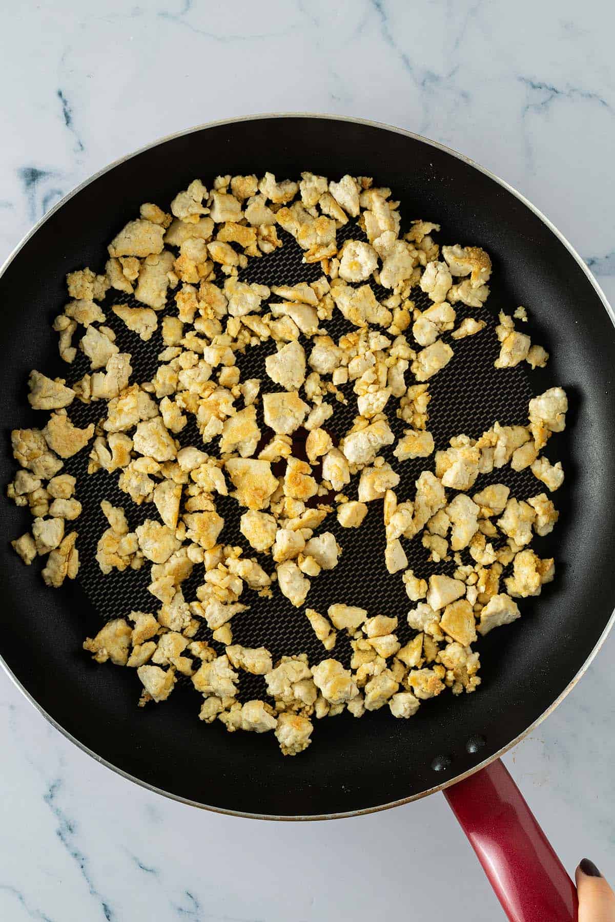 Gebratener Tofu vor dem W&uuml;rzen, hellgolden angebraten in einer beschichteten Pfanne.