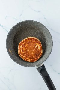 Goldbraun angebratener Pancake in einer kleinen Pfanne.